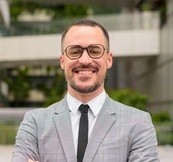 a man with dreadlocks standing in front of a building